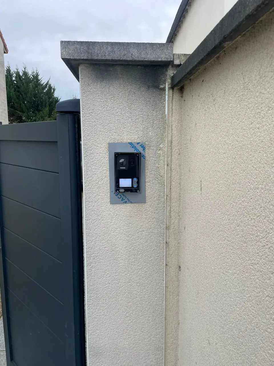 Visiophone installé sur le pilier d'un portail de pavillon lors d'une recherche de panne