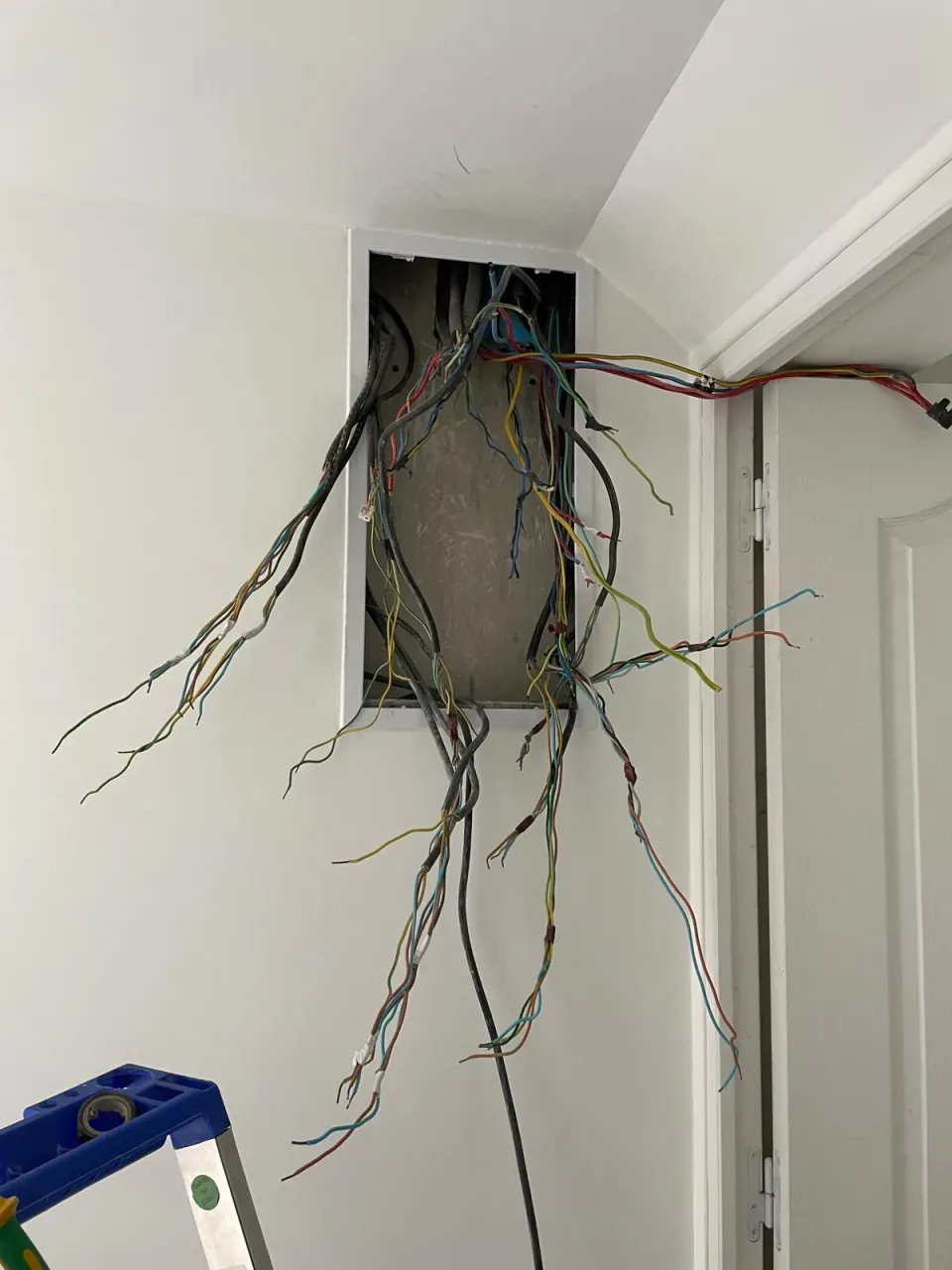 Fils électriques en attente avant la pose d'un nouveau tableau – rénovation d'appartement